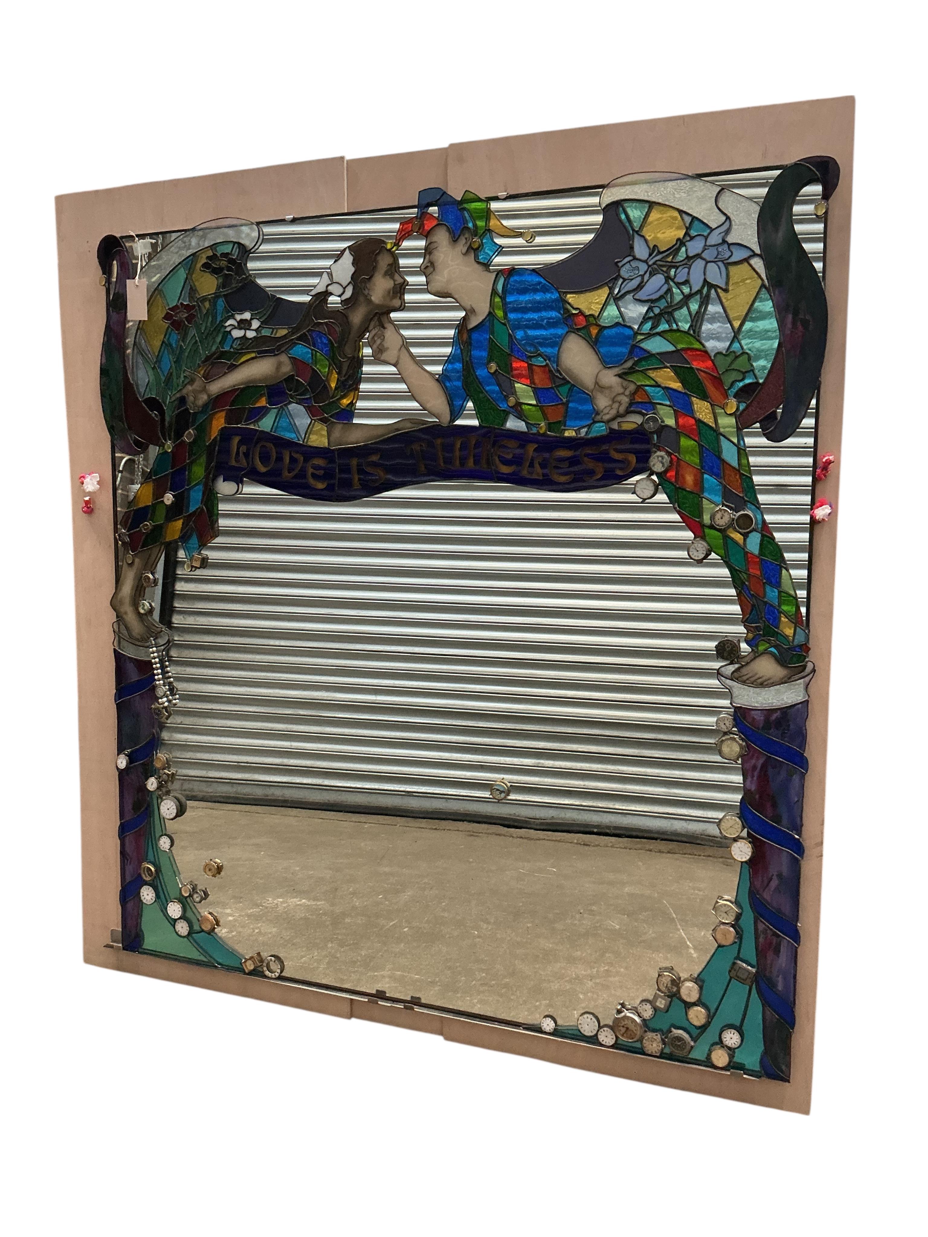 A Contemporary stained glass overmantel mirror “Love is Timeless” by Brighton artist Annelies Clark, the plate inset assorted wristwatch heads, width 128cm, height 138cm